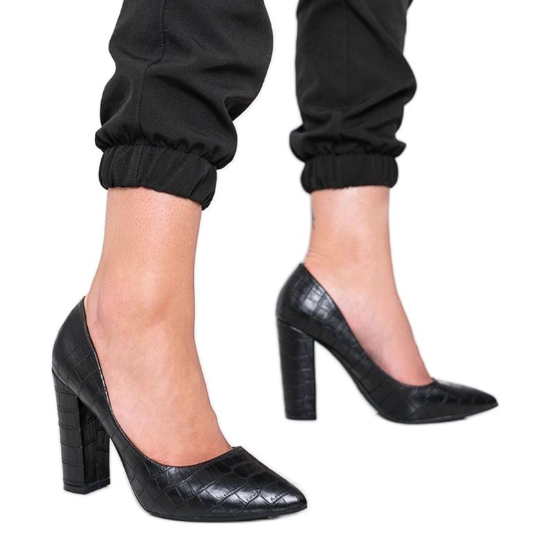 Zapatos de tacón negros en un poste con un patrón de piel de serpiente This Way