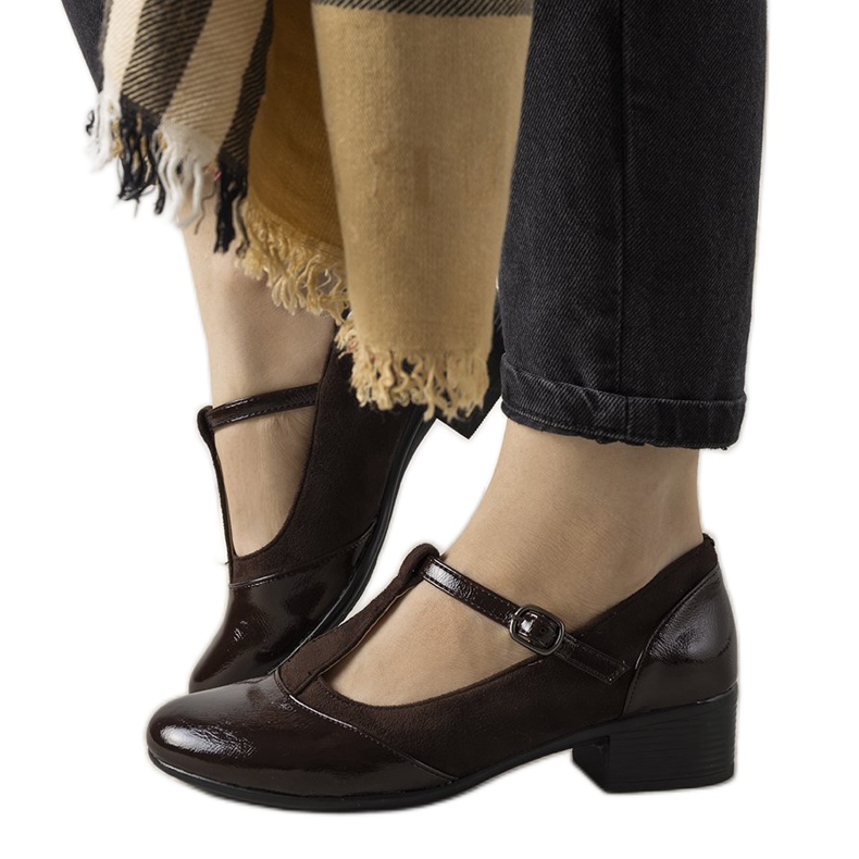 Zapatos marrones sobre un pilar con una puntera de Manam barnizada marrón Zapatos marrones sobre un pilar con una puntera de Manam barnizada marrón