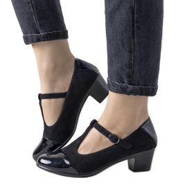 Zapatos de tacón negros sobre un pilar con puntera de postre barnizada