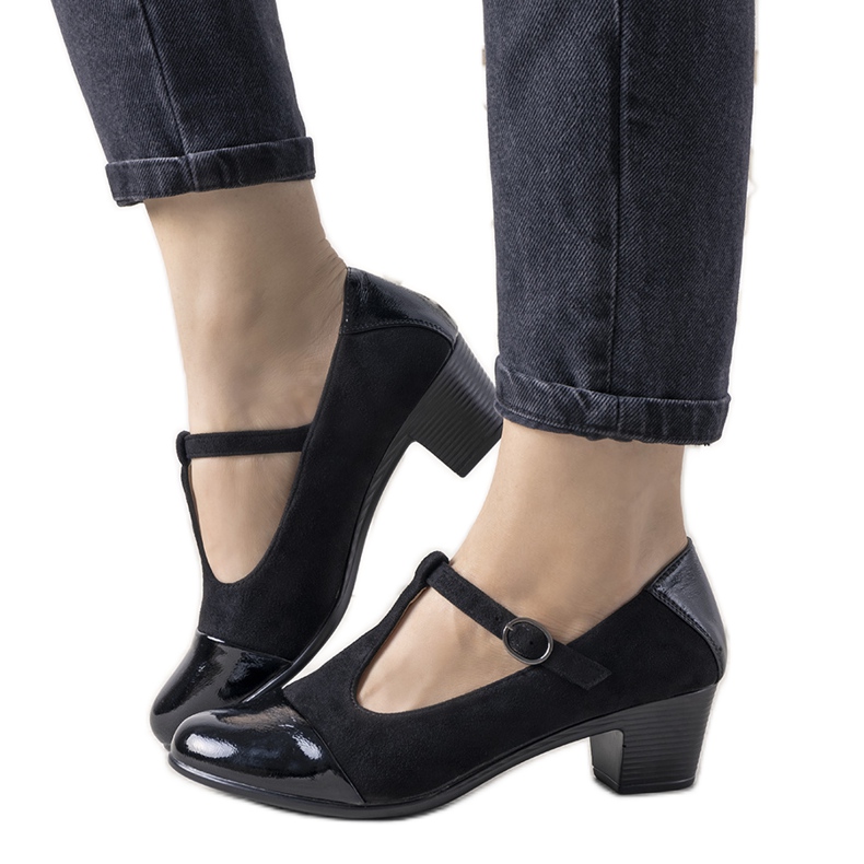 Zapatos de tacón negros sobre un pilar con puntera de postre barnizada