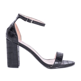 Sandalias negras en el poste de Millo negro