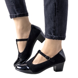 Zapatos de tacón negros sobre un pilar con puntera de postre barnizada
