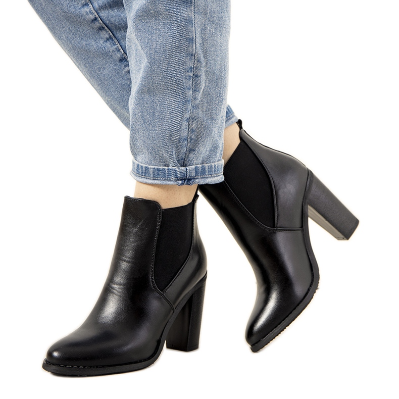 Botas negras aisladas en el poste de Castro negro