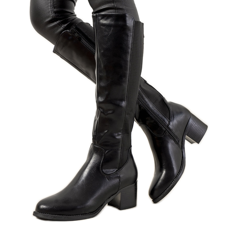 Botas negras en el poste Jurado aislado negro Botas negras en el poste Jurado aislado negro