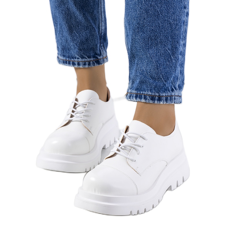 Zapatos blancos en una suela de tractor de Henta