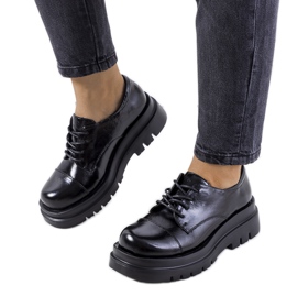 Zapatos negros en una suela de tractor de Henta Zapatos negros en una suela de tractor de Henta