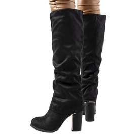 Botas negras en el puesto de Ives negro