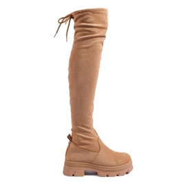Botas hasta el muslo de mujer en una plataforma beige.