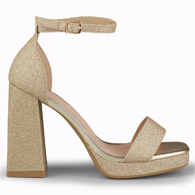 Sandalias doradas brillantes en un tacón alto ancho dorado