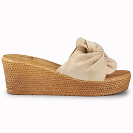 Zapatillas de mujer beige en un cómodo tacón de cuña.