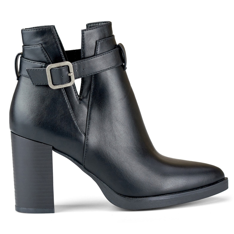 Botas negras recortadas para mujer en un poste beige
