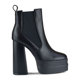 Botas negras en un poste alto y plataforma. negro