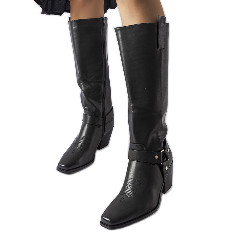 Botas de vaquero negras en el poste. negro