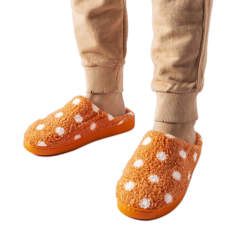 Pantuflas calentitas naranjas con lunares blancos.