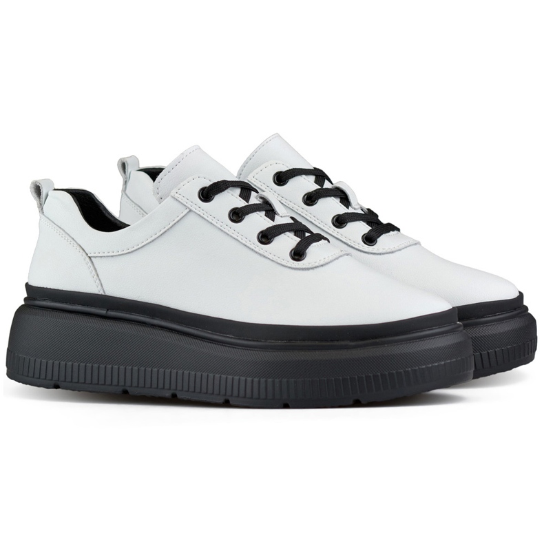 Deportivas de mujer de piel blanca con suela negra. blanco