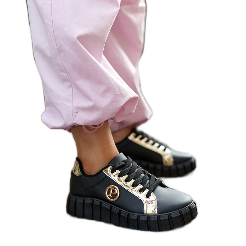 Zapatillas negras y doradas con suela Bionda masiva. negro