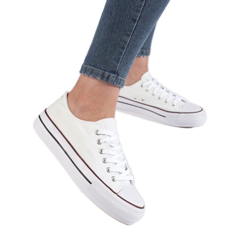 Zapatillas blancas de mujer en la plataforma. blanco