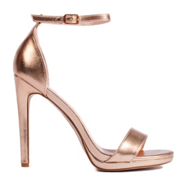 Sandalias doradas con tacón alto. dorado