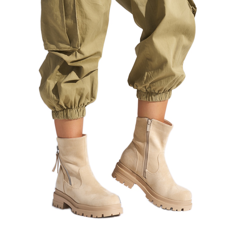 Botines de mujer beige con cremallera decorativa.
