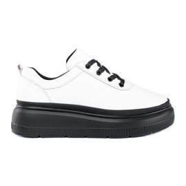 Zapatos blancos de cuero sobre una plataforma negra.