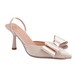 Step in style Elegantes tacones dorados de mujer con lazo.