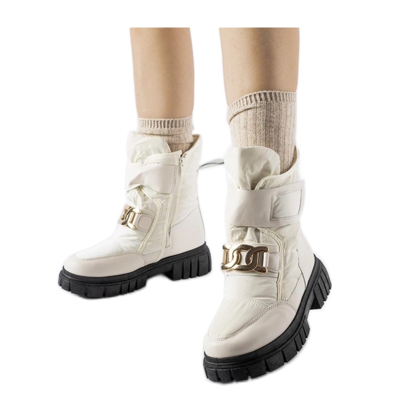 Botas de nieve beige con hebilla decorativa.