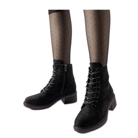 Botines clásicos negros con suela morada.