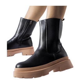 Botines negros con suela rosa claro.