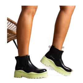 Botines negros sobre plataforma verde
