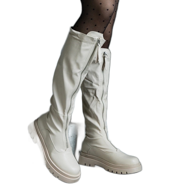 Botas de ecopiel beige con tacón plano decorado con cremallera.