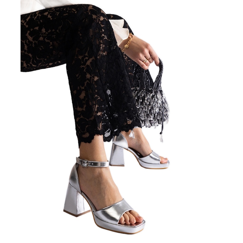 Sandalias de mujeres plateadas con un tacón metálico masivo plata