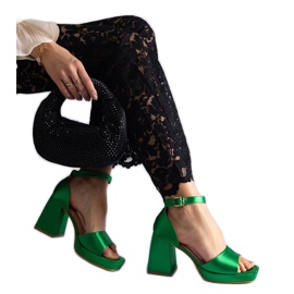 Sandalias de raso verde con tacones enormes.
