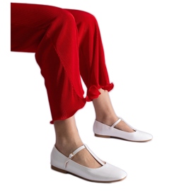 Bailarinas de charol blanco con cinturón.