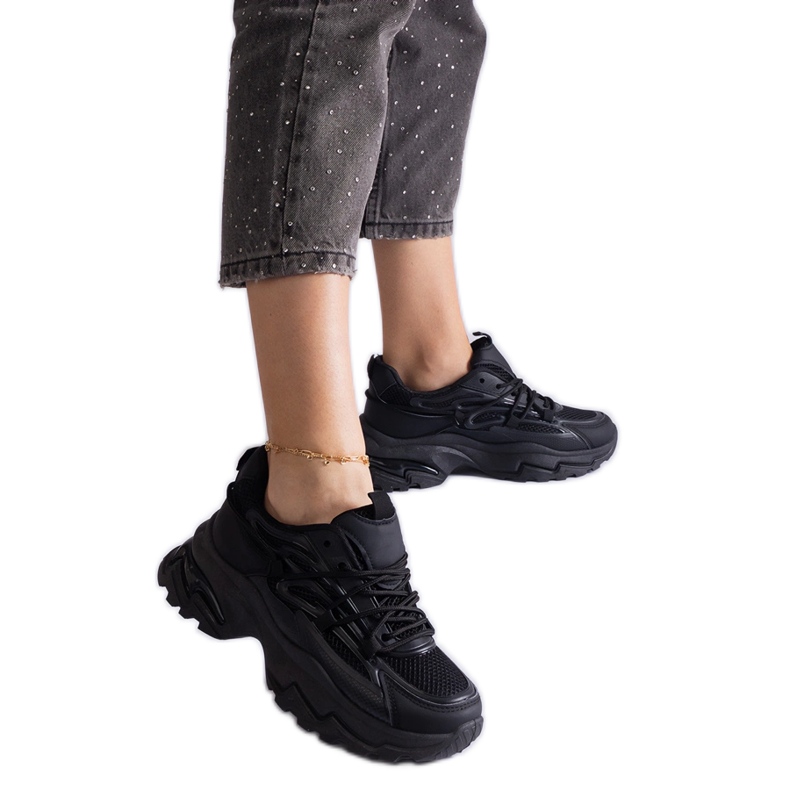Zapatillas de deporte de deportes negros en una suela masiva