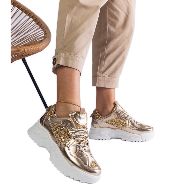 Zapatillas de mujer doradas con inserciones de purpurina. dorado
