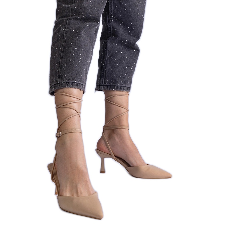 Tacones beige altos con un tacón abierto atado alrededor del tobillo