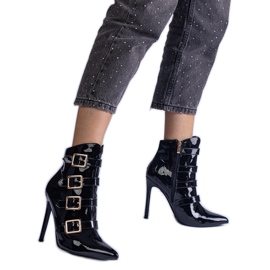 Botas negras barnizadas en un alfiler con hebillas negro