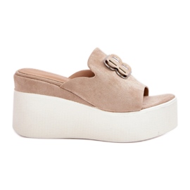Zapatillas en la plataforma y cuñas con adorno beige
