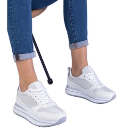 Zapatillas blancas de mujer en la plataforma. blanco