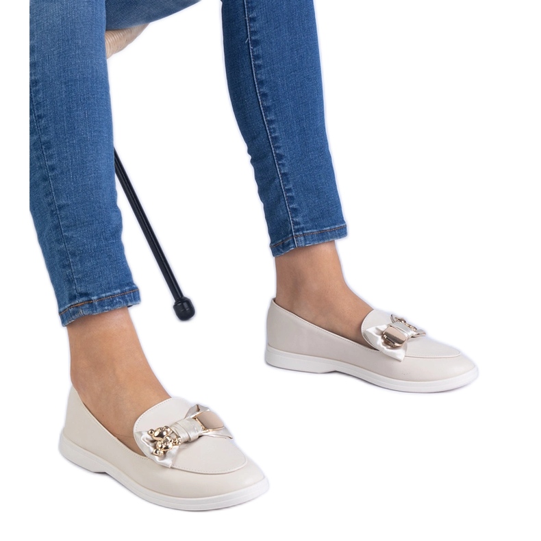 Mocasines beige decorados con un arco y un oso de peluche dorado Mocasines beige decorados con un arco y un oso de peluche dorado