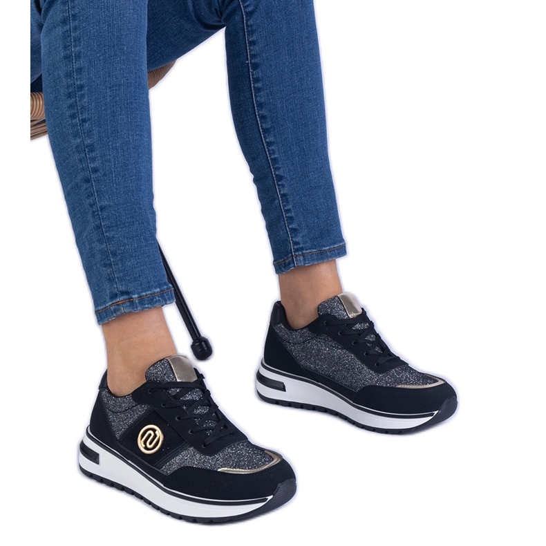 Zapatillas negras brillantes con una decoración dorada negro