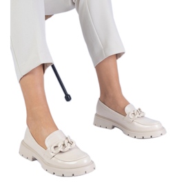 Mocasines barnizados beige con una cadena