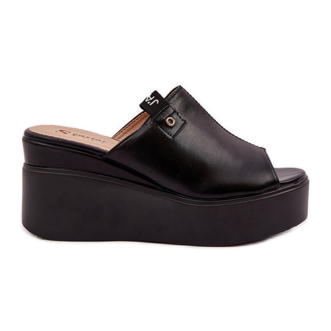 Zapatillas en la plataforma y un cuero negro ecológico de cuñas