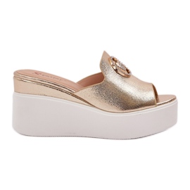 Zapatillas en la plataforma y cuñas con un adorno dorado