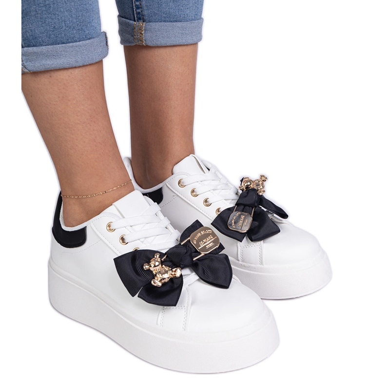 Zapatillas negras decoradas con un arco y un oso de peluche dorado negro