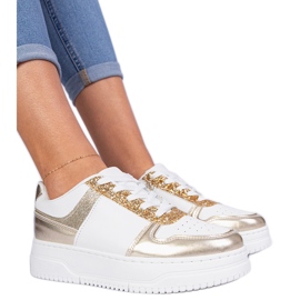 Zapatillas doradas para mujeres en una suela gruesa decorada con brillo dorado