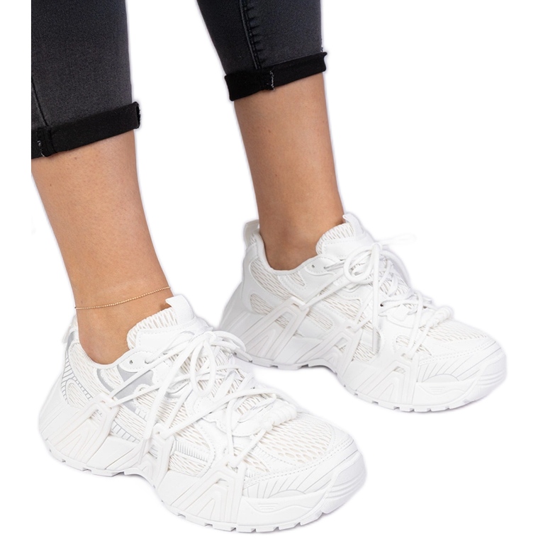 Zapatillas blancas elegantes en una suela masiva blanco