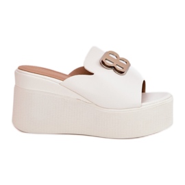 Zapatillas en la plataforma y cuñas con un adorno blanco