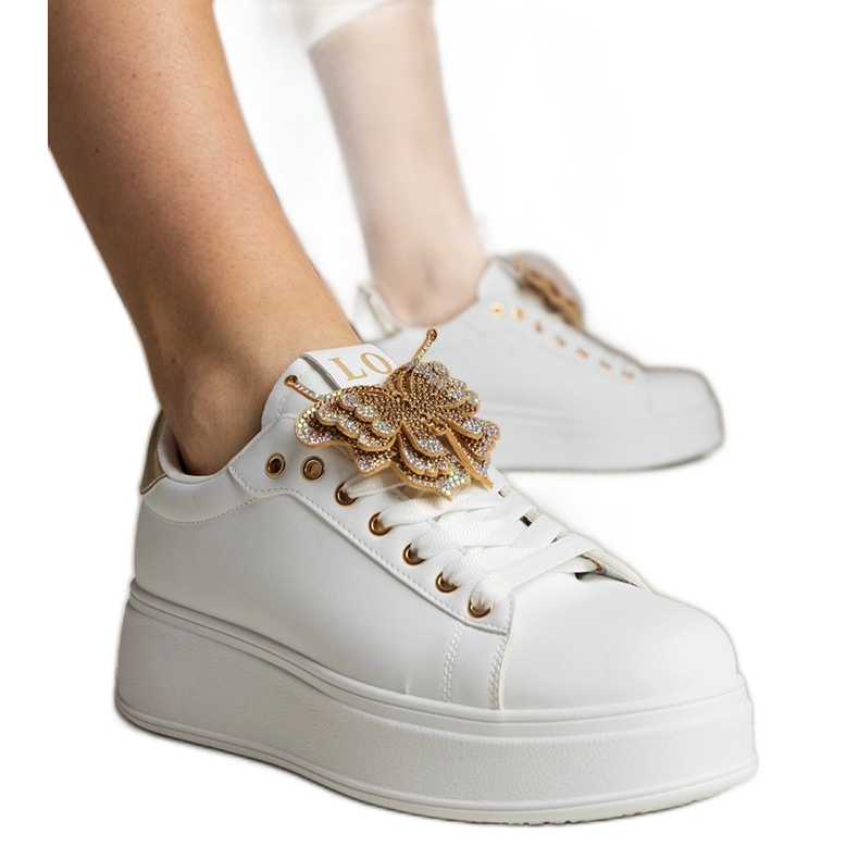 Zapatillas blancas y doradas decoradas con una mariposa con circones blanco