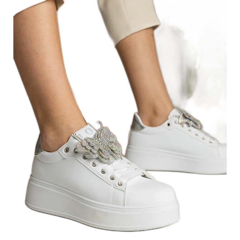 Zapatillas blancas y plateadas decoradas con una mariposa con circones blanco